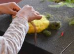 Filzarbeit – Kind gestaltet eine kleine Schildkröte aus bunter Wolle.